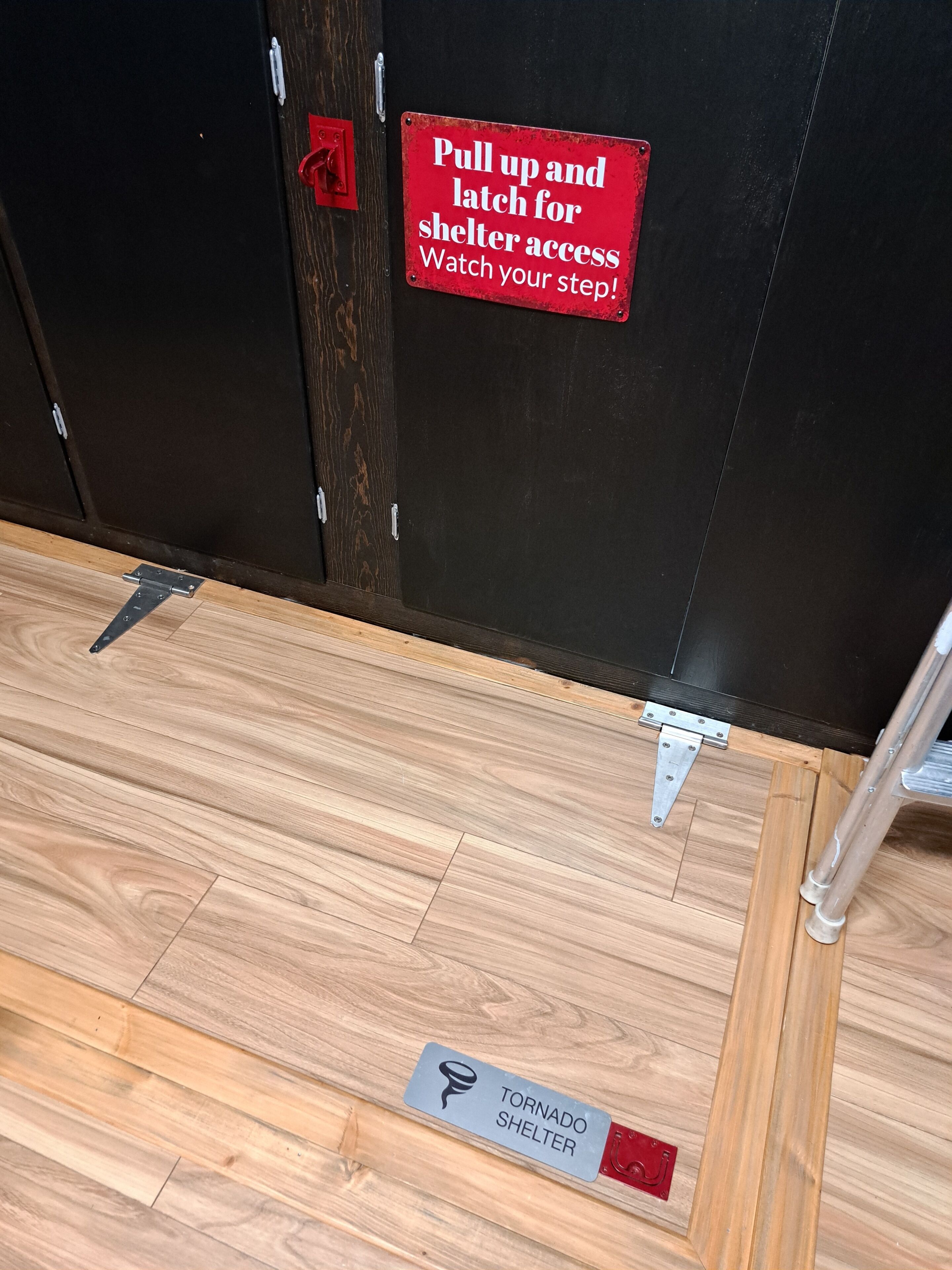 Un pavimento in legno con un cartello che indica un rifugio antitorsione.