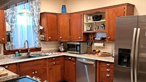 Una cocina moderna con armarios de madera, electrodomésticos de acero inoxidable y una alfombra estampada.