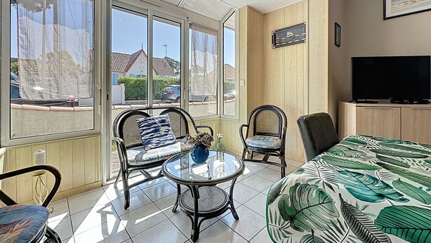 A room with a large window, a television, a sofa, and a chair. - Ker Eric by Interhome (Tharon Plage)