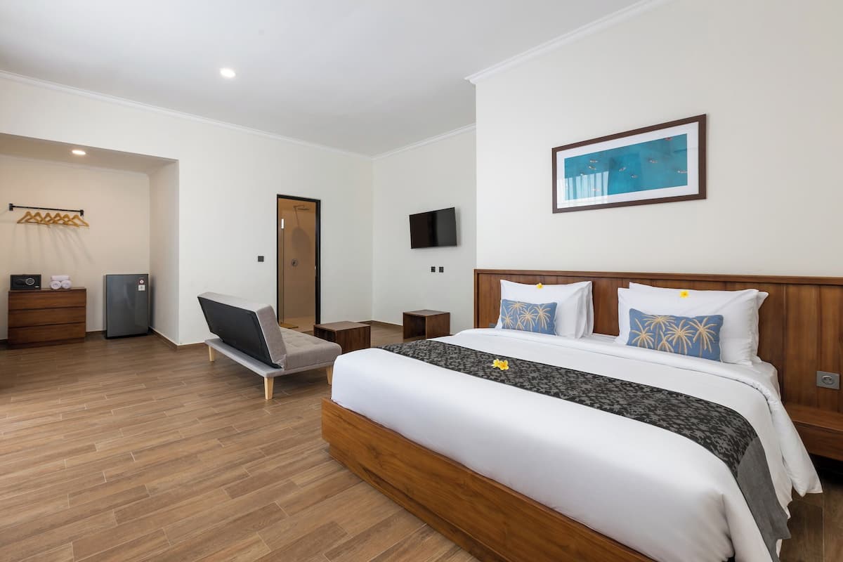 Een hotelkamer met een houten bed, een flatscreen televisie, een houten dressoir en een stoel.