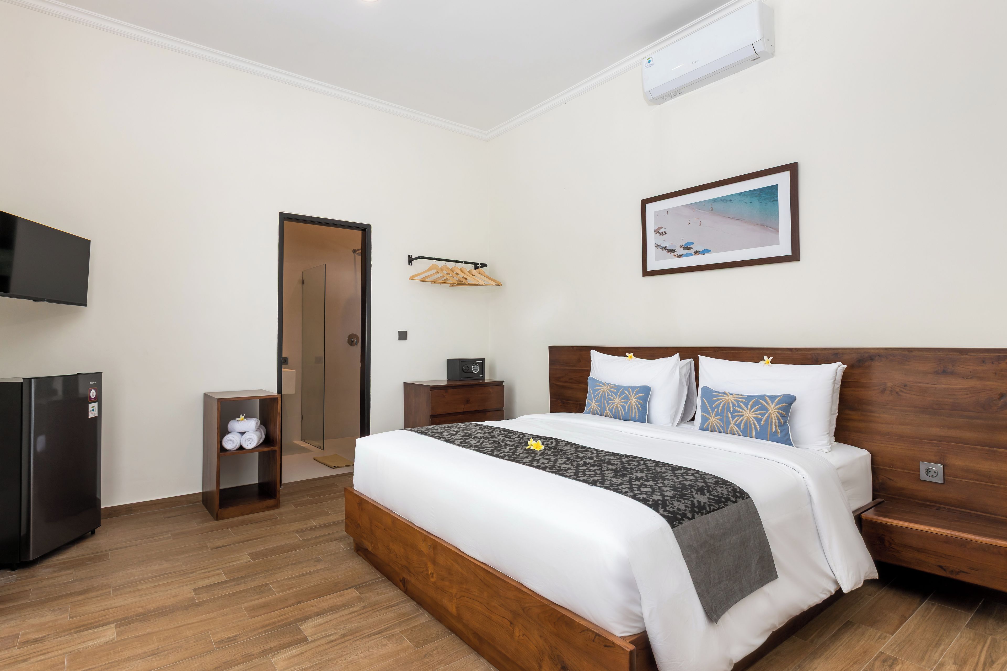 A hotel room with a bed, a TV, a wardrobe, and a bathroom.