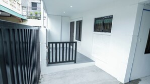 A modern building with a concrete floor, a metal gate, and a small balcony with a black railing. - Semi-detached newly renovated home in a friendly neighborhood (Las Piñas)