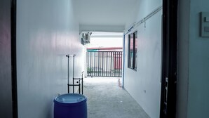 A narrow hallway with a blue barrel, a metal rack, and a gate leading to an outdoor area. - Semi-detached newly renovated home in a friendly neighborhood (Las Piñas)