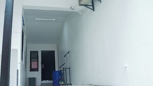 A narrow hallway with a door at the end, a blue barrel, and a metal rack. - Semi-detached newly renovated home in a friendly neighborhood (Las Piñas)