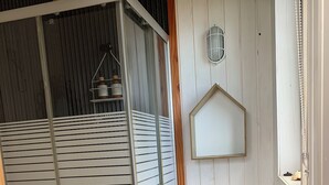 A bathroom with a glass-enclosed shower, a toilet, and a wooden vanity. - Tiny house Pilolcura (Valdivia)