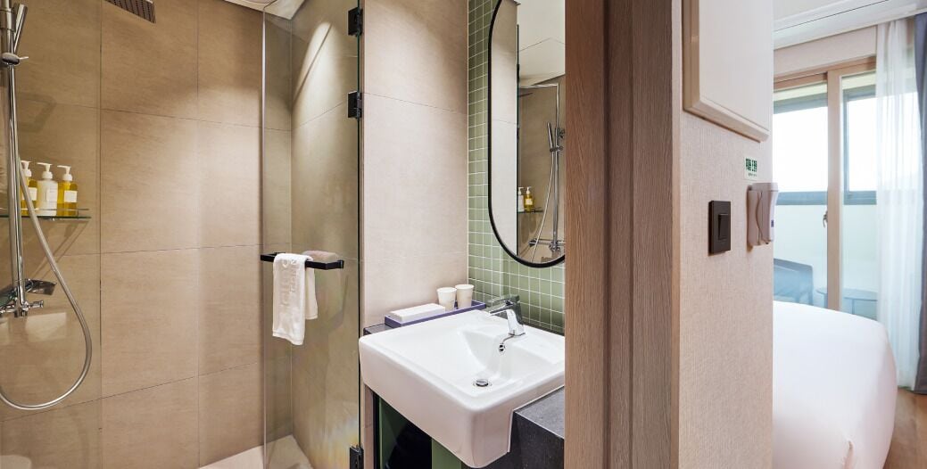 A modern bathroom with a shower, sink, and mirror.