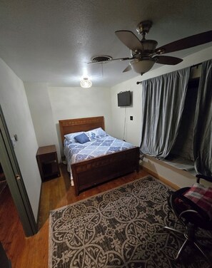 A bedroom with a bed, a ceiling fan, a TV, and a window with curtains. - Sleep like a Baby near the Medical Center (Houston)