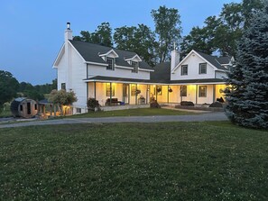 A two-story house with a covered porch, a chimney, and a well-maintained lawn. - Relax, Recharge & Reconnect at Amberleigh Guest House (Tichborne)