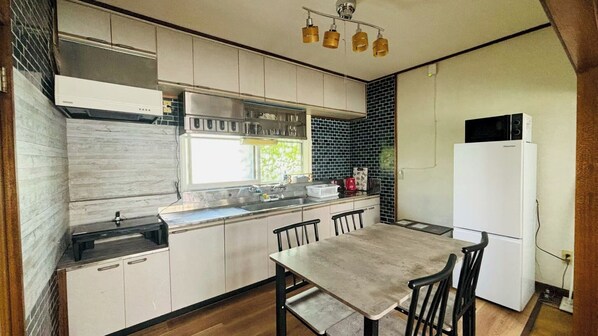 Kylskåp, mikrovågsugn, spishäll och grytor/köksredskap