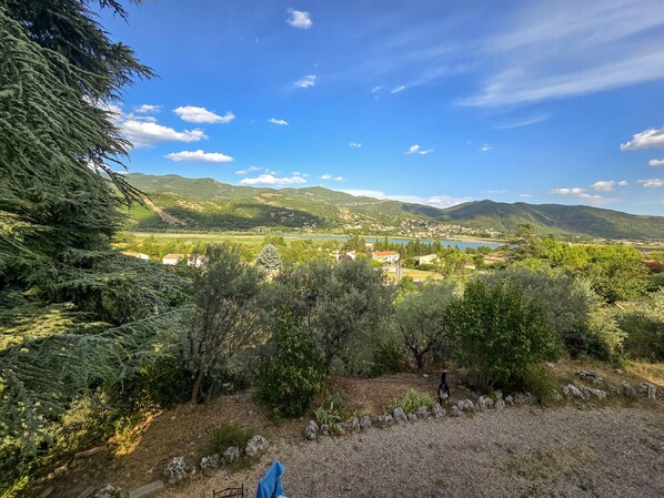 Un paysage pittoresque d’une région montagneuse avec un lac, des maisons et des arbres.
