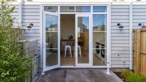 A residential property with a sliding glass door entrance leading to a covered patio area.
