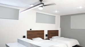 Ein modernes Hotelzimmer mit einem großen Bett, einem Schreibtisch und einem Deckenventilator.
