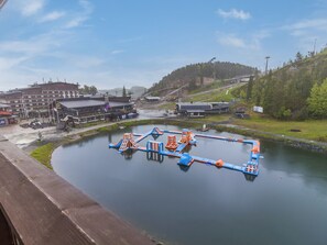 Vista junto al río con parque acuático, edificios y un puente.