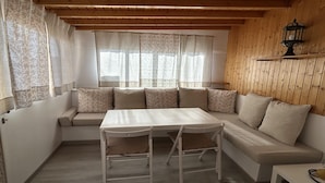 A cozy room with a sofa, a small table, and a window with curtains. - Welooveyou Wildlife Zen (La Lajita)