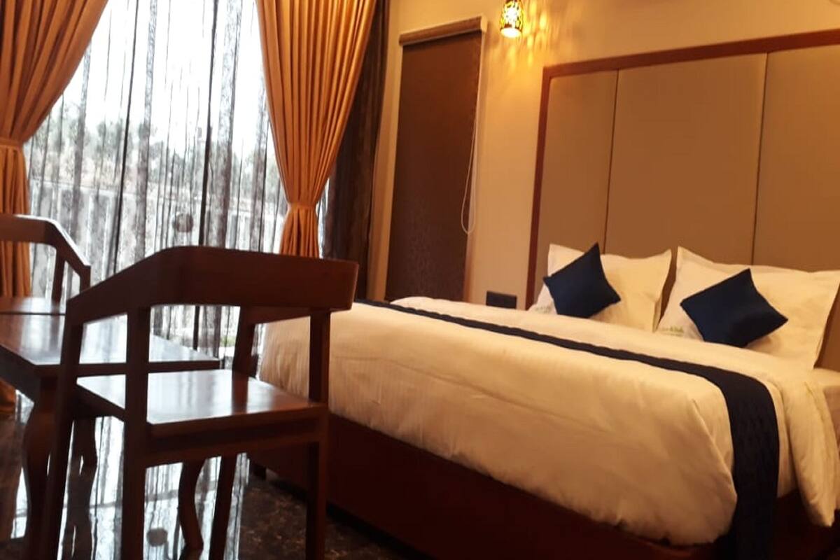A hotel room with a bed, a desk, and a chair.