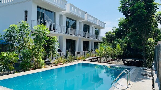 Un edificio moderno de dos pisos con una piscina en primer plano.