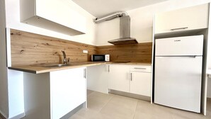 Una cocina moderna con protector contra salpicaduras de madera, electrodomésticos de acero inoxidable y armarios blancos.