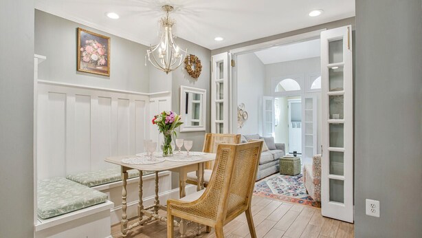 A dining area with a table, chairs, a bench, a chandelier, and a view into another room. - Historic Row Home in Downtown Annapolis (Annapolis)