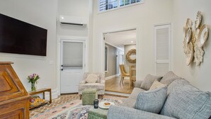 A spacious living room with a large grey sofa, a wooden cabinet, and a patterned rug. - Historic Row Home in Downtown Annapolis (Annapolis)