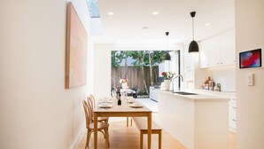 Een moderne keuken met een eethoek, houten meubels en uitzicht op de achtertuin.