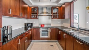 A modern kitchen with wooden cabinets, stainless steel appliances, and a central island. - Blueground | Burj Residence Phase I & II, pool, nr Burj Khalifa (Dubai)