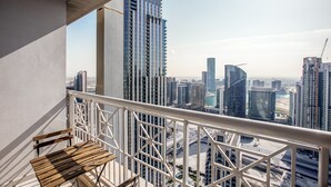 A balcony with a view of a cityscape, including high-rise buildings and a construction crane. - Blueground | Burj Residence Phase I & II, pool, nr Burj Khalifa (Dubai)