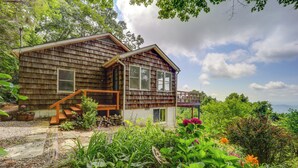 A wooden cabin with a porch, surrounded by lush greenery and flowers. - Little Switzerland Cabin w/ Stunning Mtn Views (Marion)