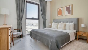 Una habitación de hotel moderna con una cama grande, un escritorio y vistas a la ciudad.