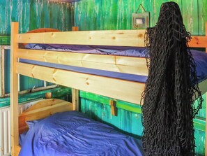Una cama litera con estructura de madera y colchón azul.