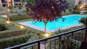 A balcony with a table, two wine glasses, and a bowl of olives. - A 10-minute walk from Lake Garda, quiet area, a playground 80 m (Raffa)