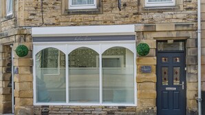 A building facade with a large arched window and a dark blue door. - The Old Post Office - UK49450 (Haltwhistle)