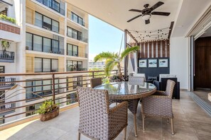 A balcony with wicker furniture, a glass table, and potted plants. - Top Views & Signature Comfort - Walk Everywhere 2BD Condo for rent in Amapas, Pu (Puerto Vallarta)