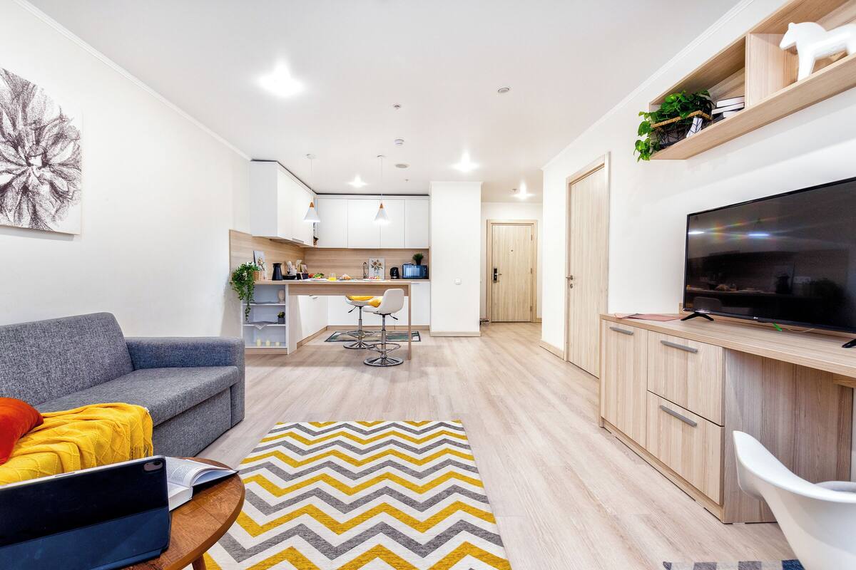 A modern living room with a sofa, a coffee table, and a TV stand.