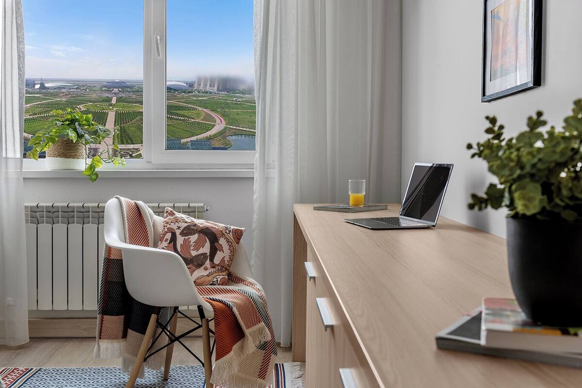 A modern room with a view of a green landscape and a river.