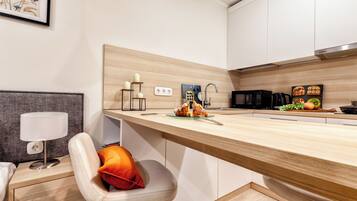 Una cocina moderna con encimera de madera, un fregadero y una zona de comedor con una silla y una mesa.