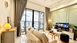 A modern living room with a sofa, a coffee table, a TV, and a balcony with a city view.