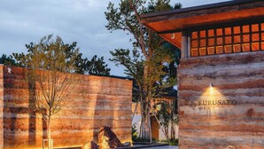 A stone wall with the name "FURUSATO SHACK" illuminated by lights. - Furusato Shack (Pranburi)