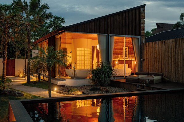 A modern house with a large glass window, a pool, and a wooden deck.