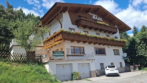Un immeuble à plusieurs étages portant une enseigne indiquant « Pension RAZIL » et « Gasthof Pension RAZIL ».