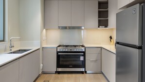 A modern kitchen with a Bosch oven, stainless steel appliances, and light-colored cabinetry. - Maison Privee - Creekside Elegance w/ Canal Vws at Creek Beach (Dubai)