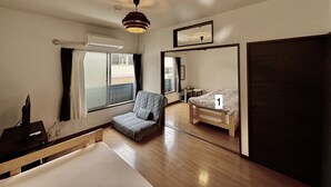 Ein Zimmer mit Bett, Stuhl, Schreibtisch und Fenster.