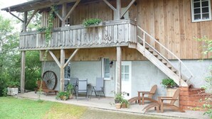 Una casa de madera con balcón, mobiliario exterior y un gran carrusel.