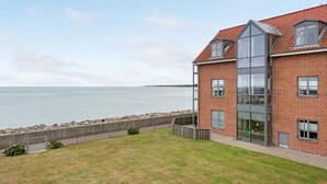 Un edificio moderno con fachada de ladrillo, ventanas amplias y vista al mar.