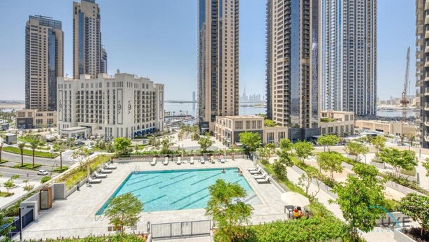 A high-rise residential building complex with a swimming pool and landscaped areas.