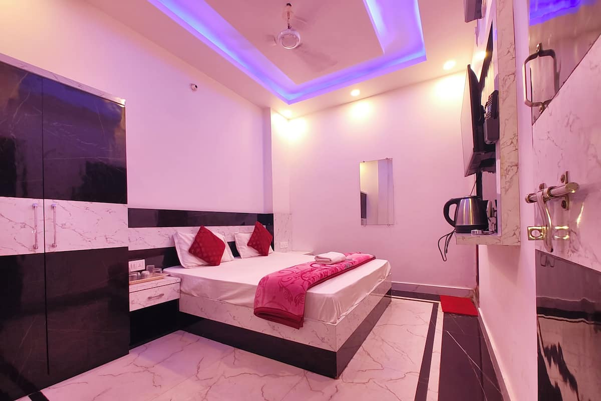 Een moderne slaapkamer met een bed, nachtkastjes, een spiegel en een plafondlamp.
