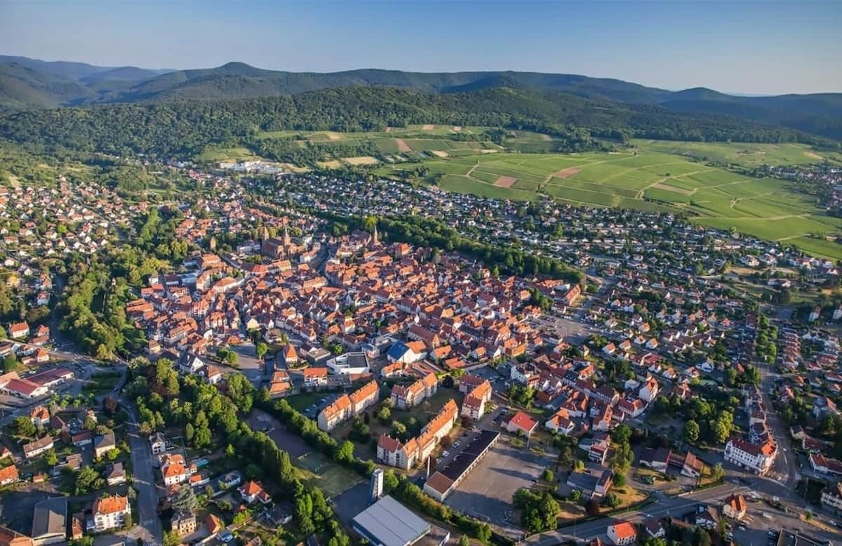 A town with a dense cluster of buildings, roads, and green fields.