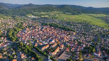 A town with a dense cluster of buildings, roads, and green fields.