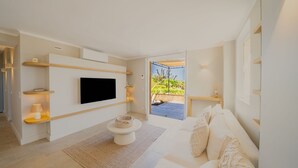 A modern living room with a flat-screen TV, a sofa, a coffee table, and a balcony with a view. - Charming house - AC/2 BR/4P - Saint-Tropez (Saint-Tropez)