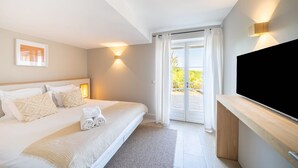 A bedroom with a bed, a TV, and a sliding glass door to the outside. - Charming house - AC/2 BR/4P - Saint-Tropez (Saint-Tropez)