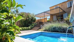 A swimming pool with a patio area, steps leading to a house, and lush greenery. - Charming house - AC/2 BR/4P - Saint-Tropez (Saint-Tropez)